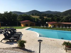a swimming pool with lounge chairs next to a house at villaggio casina del duca in Pescolanciano