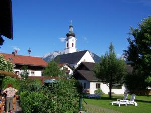 a large white building with a church with a tower at Hotel Garni Wagnerhof in Oberaudorf