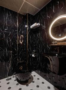 a black bathroom with a toilet and a sink at The Passion Suites Hotel & Spa in Ho Chi Minh City +36 photos