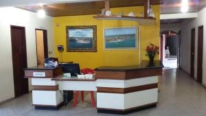 a lobby with a reception desk and a yellow wall at Salinas Praia Hotel in Salinas da Margarida