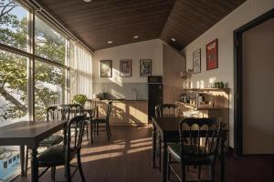a dining room with tables and chairs and a kitchen at The Passion Suites Hotel & Spa in Ho Chi Minh City