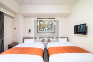 two beds in a hotel room with a tv at Arbor house in Kagoshima