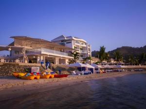 a group of boats on the beach near a building at Vitalis White Sands in Vigan