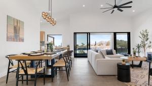 a living room with a table and a couch at Bocce PoolSpa Game Room Firepit Modern Oasis Yucca Haven by AvantStay in Yucca Valley