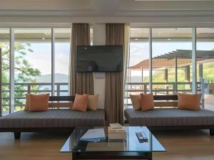un soggiorno con due divani e una TV a schermo piatto di Anilao Awari Bay Resort a Città di Batangas