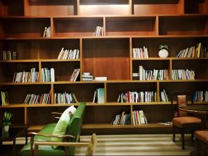 a library with wooden shelves filled with books at Med Room Korat in Nakhon Ratchasima