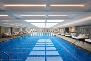 Bắc NinhにあるVinpearl Hotel Bắc Ninhのホテル内のスイミングプール(椅子付)