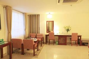 una stanza con un tavolo, sedie e uno specchio di Luxe Hotel a Dong Hoi