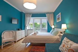 Trzy Siostry في كرينيتسا زدروي: غرفة نوم زرقاء مع سرير ونافذة