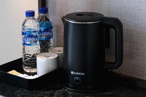 a tea kettle and two bottles of water on a counter at The Kingston Castle Malioboro in Jetis