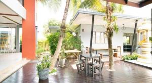 a patio with a table and chairs and palm trees at OYO 732 Juthamas Hotel in Patong Beach +60 photos