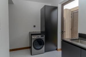 a kitchen with a washing machine and a sink at Jacaranda Luxury Villas by Maritim Villas & Residences in Balaclava