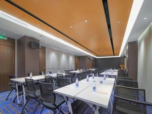 una grande sala conferenze con tavoli e sedie di Jinjiang Metropolo Shaoxing Keqiao Wanda Plaza a Shaoxing