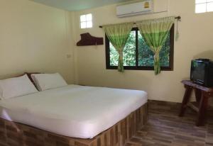 una camera da letto con un letto bianco e una finestra di Tambai Resort a Phang Nga