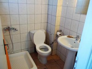 a small bathroom with a toilet and a sink at The Village in Igoumenitsa