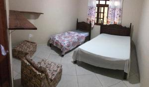 サンタ・テレサにあるRecanto MÃEFILHAのベッドルーム1室(ベッド2台、椅子、テーブル付)