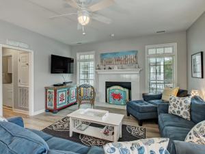 a living room with blue couches and a fireplace at Life's a Beach in Tybee Island