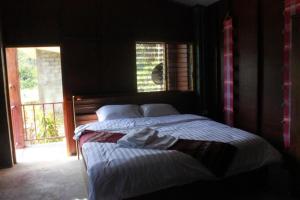 ein großes Bett in einem Zimmer mit Fenster in der Unterkunft Peisanae Faikeng Resort in Nan