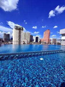 a large swimming pool with a city in the background at Chamber Suites Klcc BY BBS in Kuala Lumpur