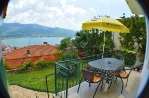 einen Tisch und einen gelben Regenschirm sowie einen Tisch und Stühle in der Unterkunft Villa Ohrid in Ohrid