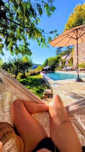 GagnièresにあるMes Maisons - Gites & Villas in the South of France - Mes Maisons Gardoises - Two Gite's with Private Pool in Cévennesのプールの横のハンモックに横たわる女性