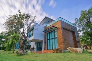 a house with two large rocks in front of it at Chatnipa Beach Resort in Rayong