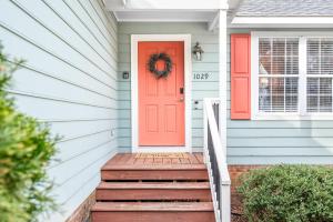 an orange door on a house with stairs at Cozy Pet-friendly home in Five Points Raleigh in Oberlin