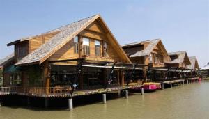 a row of houses on a pier in the water at Honey Lodge in Pattaya South