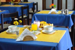 una mesa con mesas azules con comida y bebidas. en Hotel El Velero, en Villa Gesell