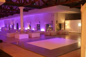 a dance floor with white chairs and purple lighting at INATEL Caparica in Costa da Caparica +37 photos