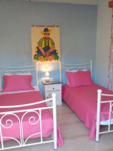 duas camas num quarto com lençóis cor-de-rosa em Cornelia em Lákka