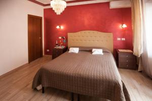 ein Schlafzimmer mit einem großen Bett mit einer roten Wand in der Unterkunft Carillon in Civitavecchia