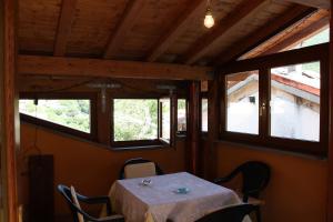 a table and chairs in a room with windows at Home in Garfagnana in Vagli di Sotto