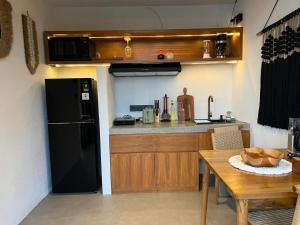 a kitchen with a black refrigerator and a table at Stone Ridge Kintamani in Kintamani