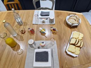 a wooden table with bread and drinks on it at Le Cardoué, chambres d'hôtes proche du Puy duFou in Chantonnay +16 photos