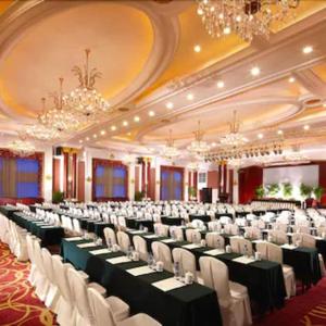 a large banquet hall with tables and chairs and chandeliers at New Century Hotel Taizhou  +234 photos