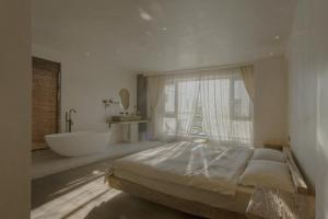 een slaapkamer met een groot bed en een bad bij 大理古城归渊民宿 in Dali (oude stad)