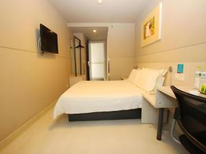 a bedroom with a bed and a desk and a television at Jinjiang Inn Zhoushan Putuo Shenjiamen in Zhoushan +131 photos