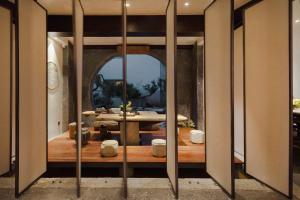 een kamer met een tafel en een grote spiegel bij 大理古城归渊民宿 in Dali (oude stad)