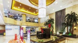 a large lobby with palm trees in a building at Linyi Blue Horizon Intenational Hotel in Linyi