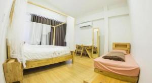 a bedroom with two twin beds and a desk at Maximize Brand New Hostel Udonthani in Udon Thani