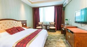 a hotel room with a bed and a desk and a television at GreenTree Alliance Zhejiang Zhoushan Putuoshan Zhujiajian Scenic Spot Hotel in Zhoushan