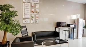 a waiting room with a couch and a table at GreenTree Alliance Suzhou Zhangjiagang Nanfeng Town Hotel in Zhangjiagang