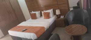 una habitación de hotel con una cama y una silla en Keton Suites and Apartments, en Abuja