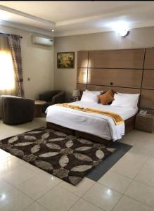 Un dormitorio con una cama grande y una alfombra. en Keton Suites and Apartments, en Abuja