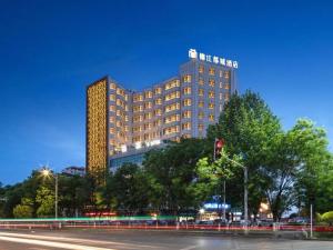 a large building on a city street at night at Metropolo Hotel Yining Development Zone Hanma Building in Kipekyüzi