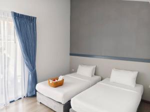 two beds in a room with a basket on them at Rapina House in Mai Khao Beach