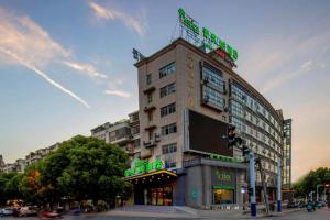 a tall building on a city street with a traffic light at Vatica Hefei Feidong County Yuzhou Central Square Hotel in Hefei