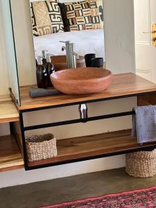 - un bol sur une commode avec un miroir dans l'établissement The Schoolhouse at Meulplaas, à Montagu