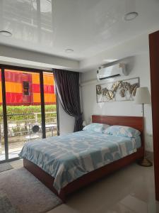 a bedroom with a bed and a large window at Уютная студия в жилом комплексе в заповедном уголке Пхукета in Ban Mai Salae